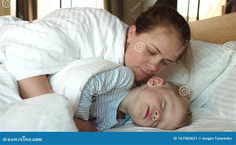 Mother Wakes Up Her Child In The Morning In Bed Son Sleeping Under A