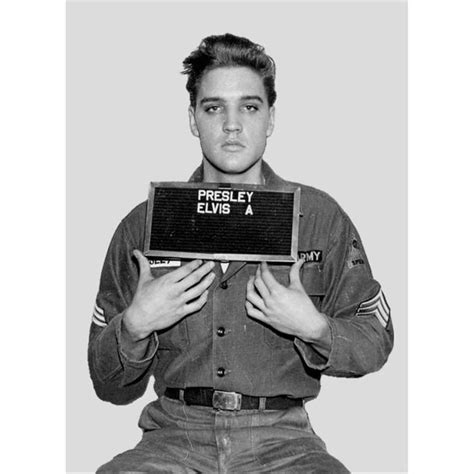 A Man Holding Up A Sign That Says Presely Elvis A In Front Of His Face