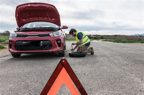Hispanic Latino Man Fixing Flat Car Tire On Roadside Waiting For Emergency Editorial Stock Photo