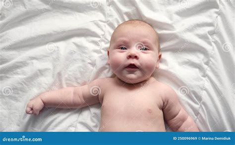 穿着尿布的快乐的裸体婴儿躺在白色的床单上摸着脸 一头红发的女婴 股票视频 视频 包括有 婴儿 户内
