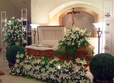 The Casket Is Decorated With White Flowers And Greenery