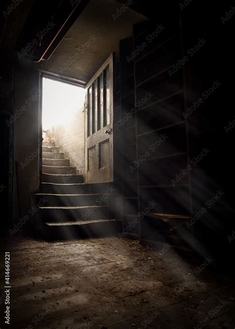 Dark And Creepy Wooden Cellar Door Open At Bottom Of Old Stone Stairs
