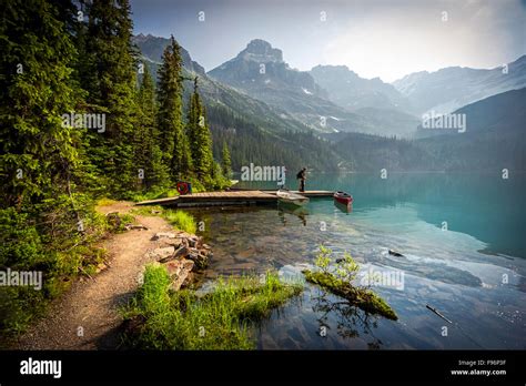 A Couple On A Dock At Lake Ohara In Yoho National Park In The Canadian