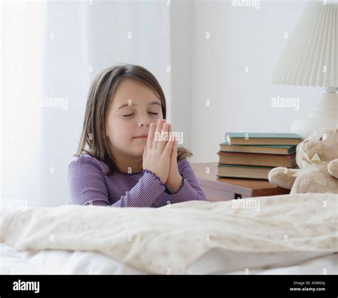 Girl Praying Next To Bed Stock Photo Alamy