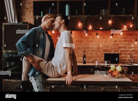 Pareja gay cariñosa en casa Dos hombres apasionados y guapos abrazan y besan en la cocina