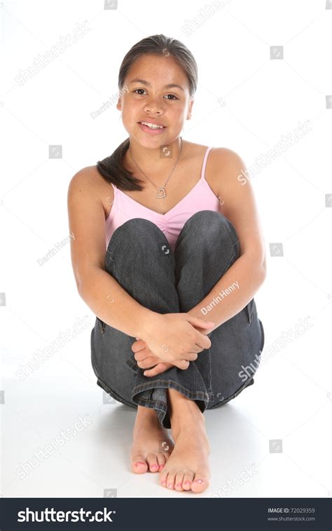 Teenager Girl Sitting With Knees Up In Studio Stock Photo