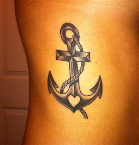 An Anchor Tattoo On The Back Of A Womans Lower Body With A Cross And