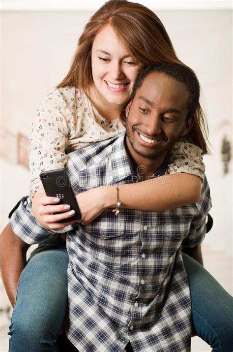 Interracial Couple Wearing Casual Clothes Interacting Having Fun Man Carrying Woman On His Back