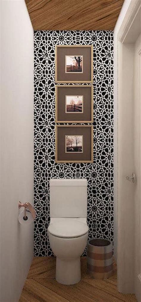 A White Toilet Sitting In A Bathroom Next To A Wall With Pictures