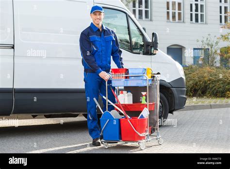 Happy Janitor Standing With Cleaning Equipment Stock Photo Alamy