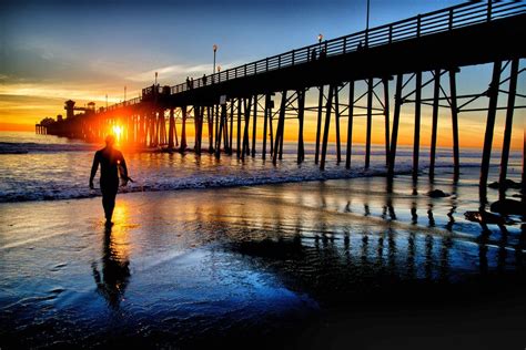 Surfer Heads In To The Sunset At Oceanside Pier Oceanside Sand