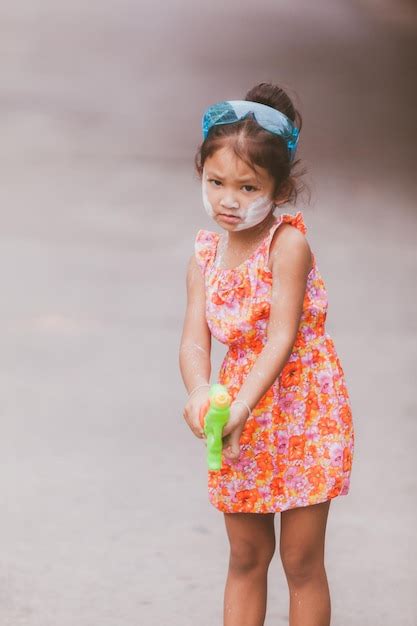 premium photo portrait of cute girl holding squirt gun outdoors