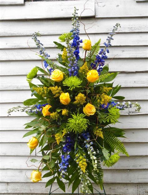 This Funeral Flower Easel Spray Combines Blue Yellow And Green Toned