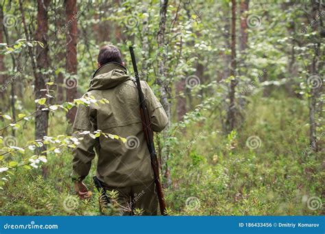 Hunter With Shotgun Walking In Forest Hunting Season Man Armed With