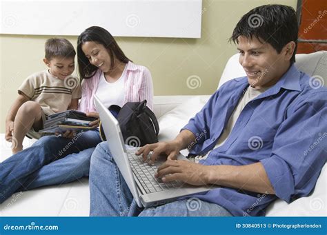 Engendre A Using Laptop Y Madre E Hijo Que Miran Dvds En El Sofá Imagen