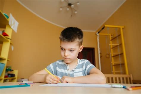 Un Niño En Edad Escolar Hace La Tarea En Casa Entrenando En La Escuela