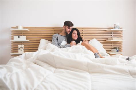 Free Photo Loving Couple Lying On The Bed And Embracing