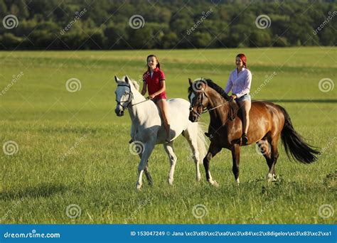 Two Young Girl Riding Horses On The Walk Without Saddle In Summer Time