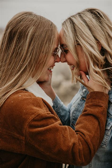 Two Women Standing Next To Each Other With Their Heads Together