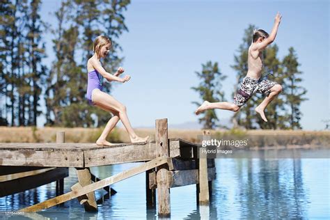 Children Jumping Into Lake From Jetty High Res Stock Photo Getty Images