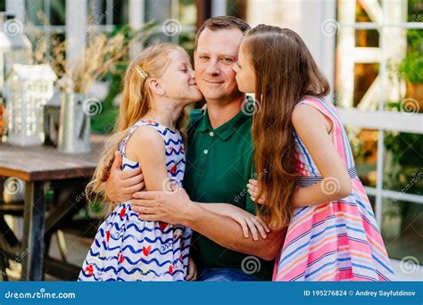 Dad Hugs Two Cute Daughters In Garden Of House Stock Photo Image Of