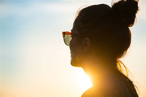 Young Woman Wearing Sunglasses Looking At Sunset Stock Photo Download