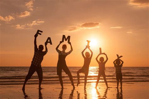 Fam Lia Feliz Que Est Na Praia No Tempo Do Por Do Sol Imagem De Stock