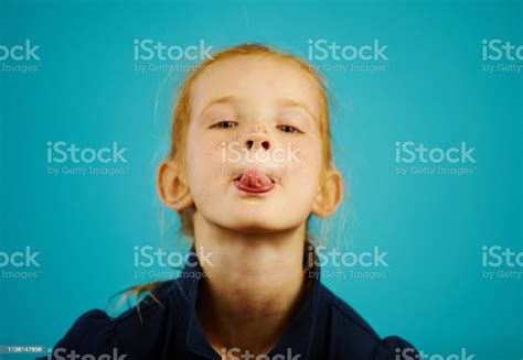 Closeup Portrait Of Naughty Redhead Girl On Blue Isolated Background