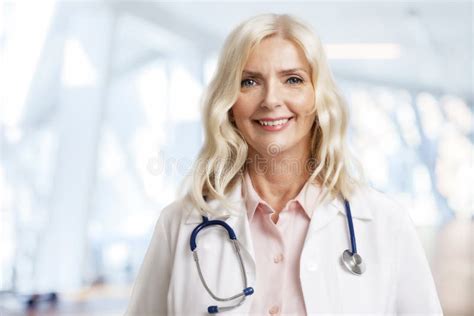 Smiling Female Doctor Standing In Her Office At The Clinic Stock Photo