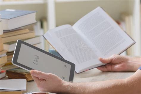 Man Holding A Modern Ebook Reader And Book In Library Stock Image