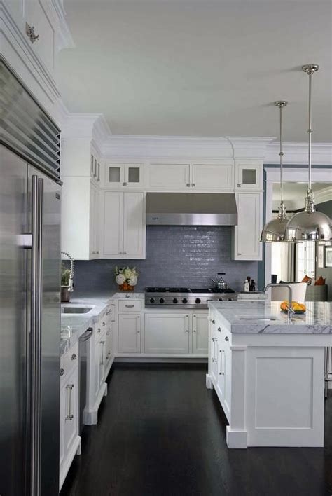 While a bright red backsplash runs the risk of looking too brash or intimidating, light gray cabinets can help to temper the look. White and blue kitchen features white shaker cabinets ...