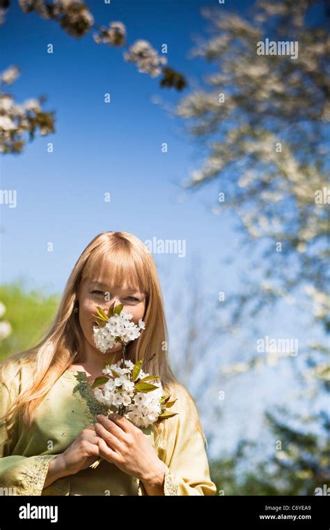 Woman Smelling Flowers Outdoors Stock Photo Alamy