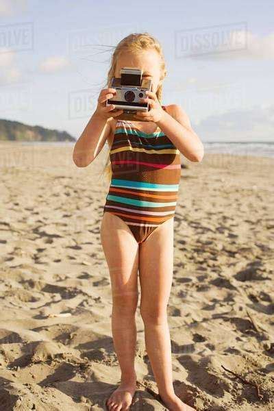 Girl Using Instant Camera On Beach Stock Photo Dissolve