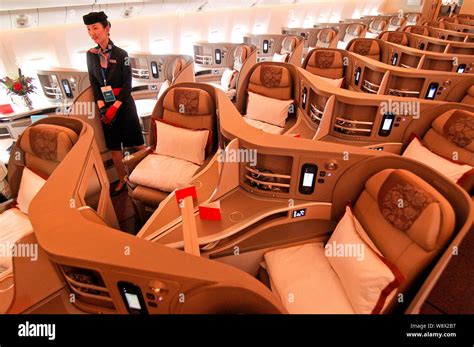 A Flight Attendant Poses In A Business Class Cabin Of A Boeing 777