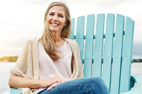 Easing In To A Stress Free Day A Mature Woman Sitting On A Deck Chair Outside Stock Image