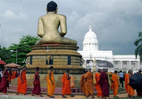 Sri Lankan Buddhist Monks Walk Around A Statue Of Lord Buddha During