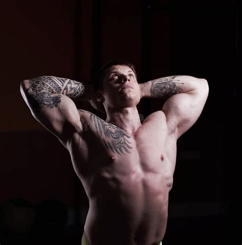 Handsome Muscular Male Bodybuilder Showing His Muscles Stock Photo