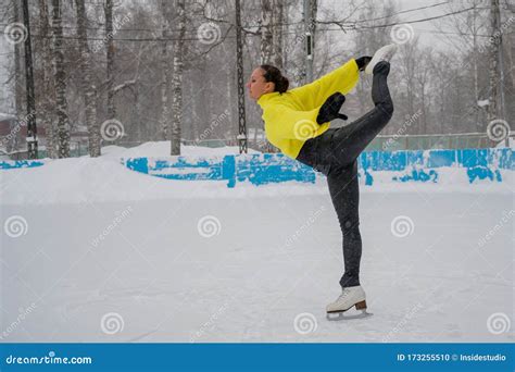 Professional Skater On An Outdoor Ice Rink A Woman On Knees Is