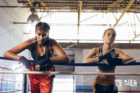 African American Female Boxers Leaning On Ropes And Looking At Camera