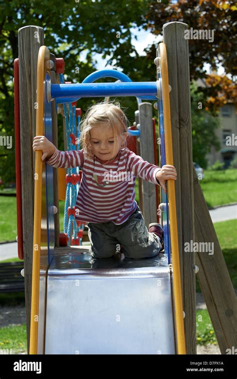 Child Blond Girl Sliding Slide On A Playground Stock Photo Alamy