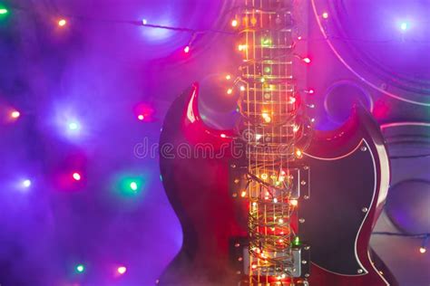 Electric Guitar With Festive Christmas Lights And Music Speakers In