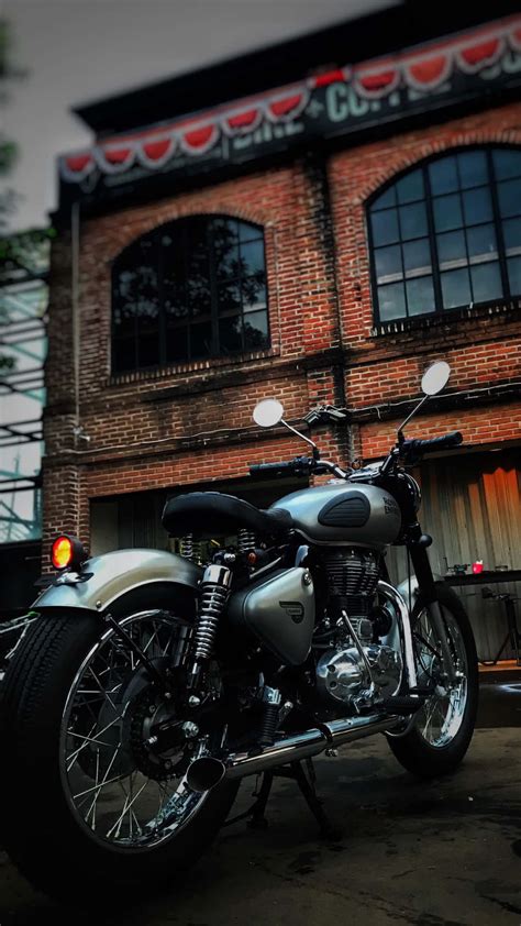 Download A Motorcycle Parked In Front Of A Brick Building