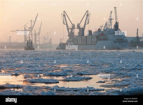 A Container Ship Moves Through The Partially Frozen Elbe In The Port Of