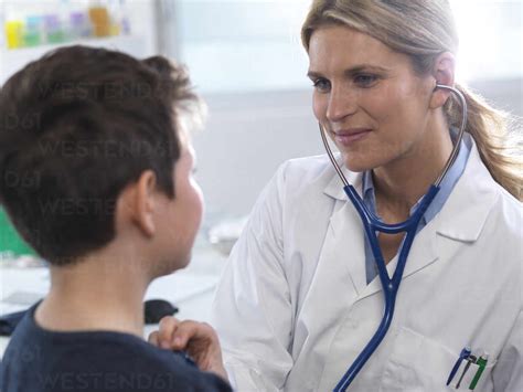 Female Doctor Listening To A Boys Heart Beat Using A Stethoscope During