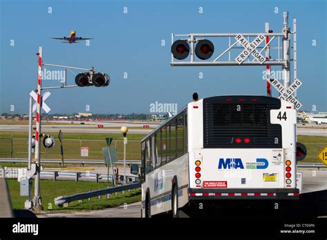 Boeing 737 At Take Off And A Bus Stopped At A Railroad Crossing At The