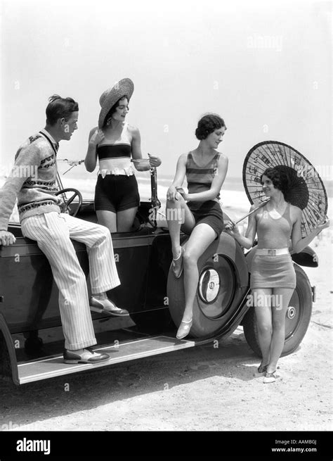 1920s 1930s Man And Three Women In Beach Clothes Or Bathing Suits Posing With Car On Running