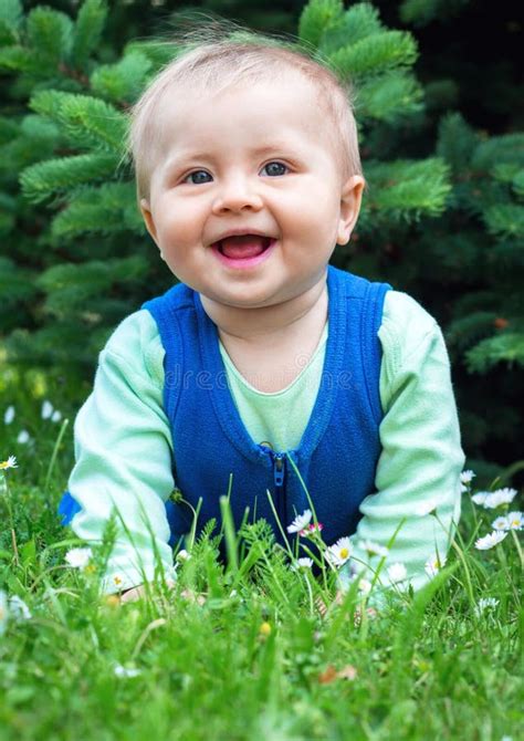 Cute Smiling Little Baby Lying On A Fresh Green Grass In A Park Stock