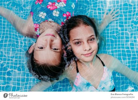 zwei schöne Teenagermädchen in einem Pool schwimmen ein