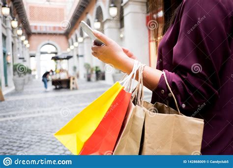 Woman Holding Shopping Bag And Using Smartphone For Shopping Online