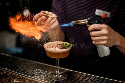 Professional Bartender Adding To An Alcoholic Cocktail In The Glass Spices From The Spoon And
